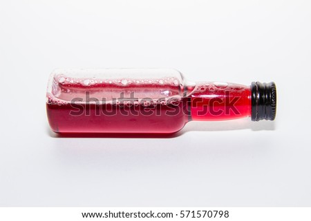 Overturned bottle with red juice,simple background.