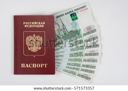 Passport and money fanned out on a white background Royalty-Free Stock Photo #571573357
