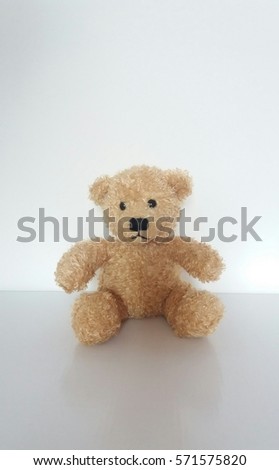 Plush brown teddy bear sitting alone.