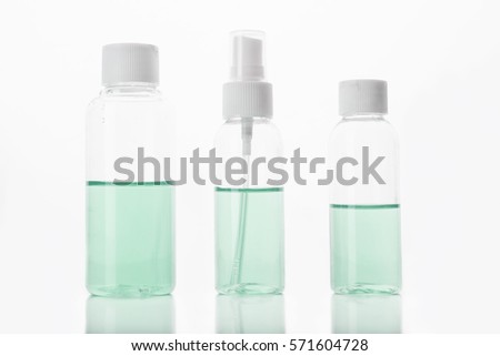 Three bottles with green liquid on white background 