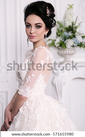 fashion studio photo of gorgeous bride with dark hair in luxurious wedding dress