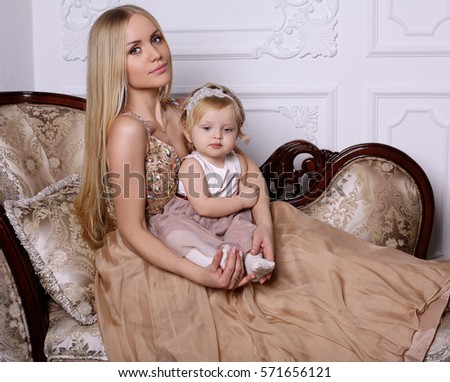 holiday photo of beautiful family. Gorgeous mother with long blond hair posing with adorable cute daughter 
