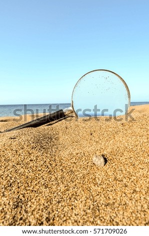Photo Picture of a Loupe Magnify Glass on the Sand Beach