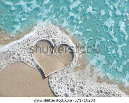 shaped heart on soft wave of the beach