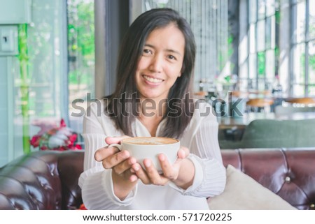Portrait of happy asian woman with coffee mug in her hands. Loving coffee concept.