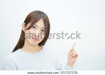 Young woman pointing something with white  background