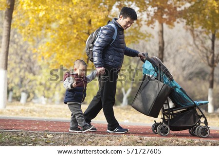 Happy real father and son walking in a park, Beijing, China
