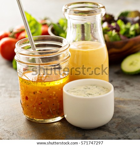 Variety of homemade sauces and salad dressings in jars including vinaigrette, ranch and honey mustard Royalty-Free Stock Photo #571747297