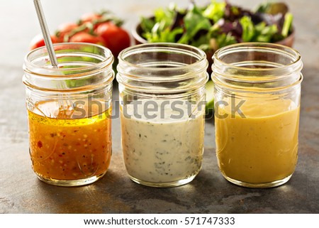 Variety of homemade sauces and salad dressings in mason jars including vinaigrette, ranch and honey mustard Royalty-Free Stock Photo #571747333