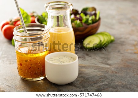 Variety of homemade sauces and salad dressings in jars including vinaigrette, ranch and honey mustard Royalty-Free Stock Photo #571747468