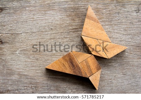 Wooden tangram puzzle in flying butterfly shape background