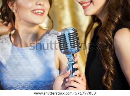 The girls sing karaoke in the restaurant.