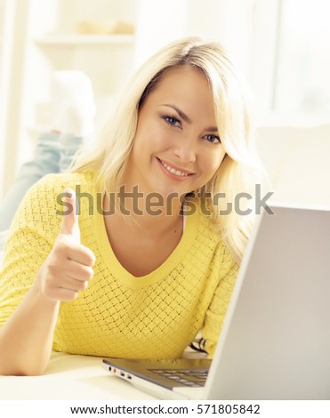 Happy blonde girl with notebook at home. Online shopping, laptop, computer concept.