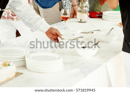 Waiter takes bowl from the table