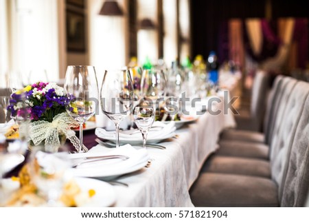 Sparkling glassware stands on long table prepared for wedding dinner