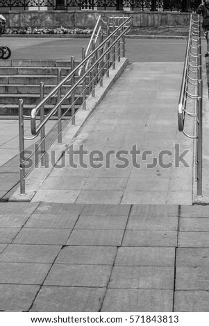 Black-and-white photograph. A stone staircase with stainless steel railings. Vacation in Yekaterinburg, the center of the city. Care for people with disabilities.