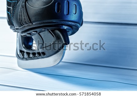 Black hockey skate with white laces on light background
