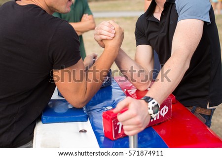 people, leisure, challenge, competition and competition concept - close up of male friends in arm wrestling