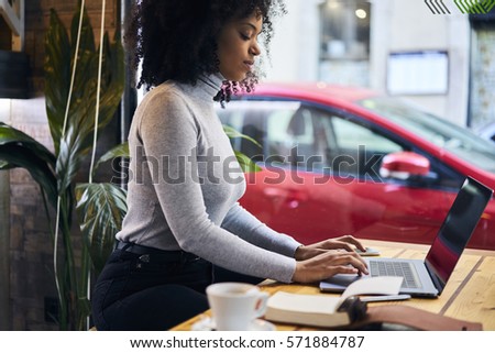 Talented female journalist blogger typing on keyboard text of her new article review working in cafe waiting for feedbacks from followers and colleagues using wireless connection to 4G internet 