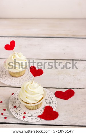 Cupcakes with red hearts for St. Valentines Day.White wooden background.Place for text. Selective focus