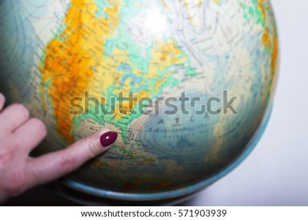 Blurred earth globe, finger pointing