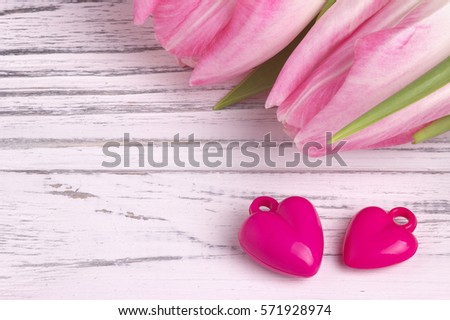 Two purple hearts with rose tulips on white painted rustic white wooden background. Valentine Day. Wedding