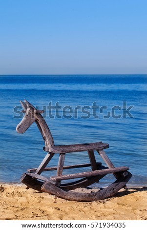 Wooden horse, rocking horse, antique toy on the beach feel lonely, childen lonely concept.