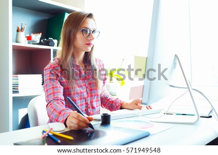 Graphic designer drawing something on graphic tablet at the home office