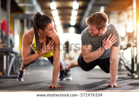  Man and woman strengthen hands at fitness training Royalty-Free Stock Photo #571976104