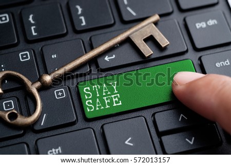 Closed up finger on keyboard with word STAY SAFE Royalty-Free Stock Photo #572013157