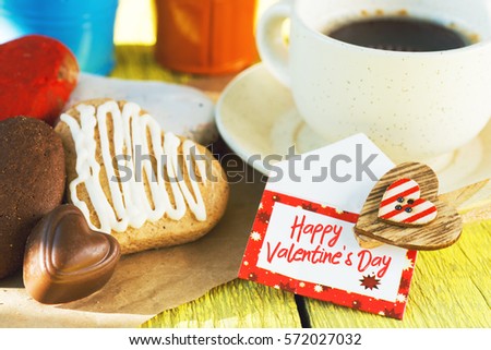 Heart shaped cookies (big and small as couple), cup of coffee, bouquet of flowers decoration on yellow table. sunny morning. Romantic breakfast or Valentine's Day Breakfast. Toned imag