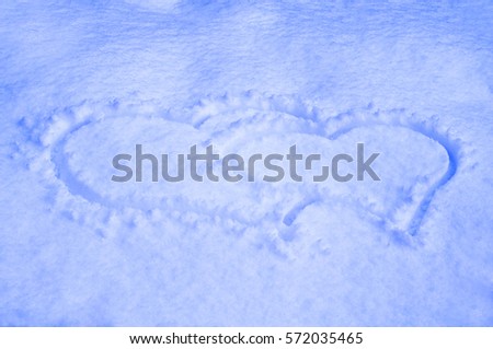 Two hearts drawn on the snow close up