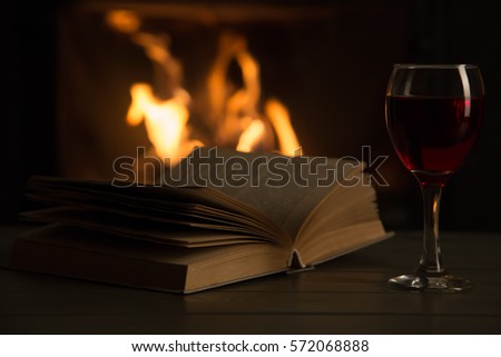 Book and glass of wine in front of fireplace
