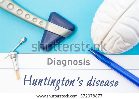 Neurological diagnosis of Huntington's disease. Neurological hammer, human brain figure, tools for sensitivity testing are on table next to title of text diagnosis of Huntington disease