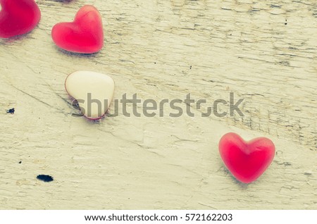 Red heart shape candy on a white rustic wooden table with space for text. Romantic love concept. Valentine's Day greetings card. Valentines theme. Top view. Copy space.