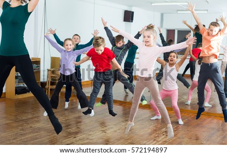 Ordinary boys and girls studying contemp dance in dancing studio Royalty-Free Stock Photo #572194897