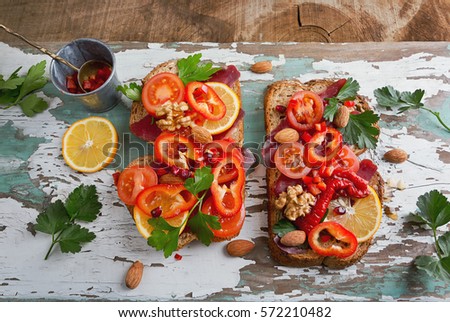 Healty Sandwiches with Lemon,Walnut, Almond, Chili, Tomato and Bacon. Old Wood Background with red sandwiches for breakfast.