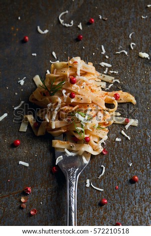 Spaghetti tomato sauce and basil on a Fork, with old steel dark background.