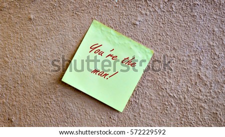 Yellow sticky note at on wall background with the word You're the man