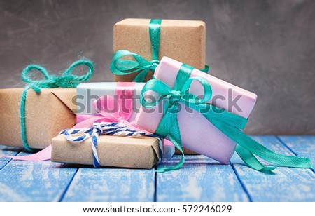 Gift box in kraft paper with bow on wooden background
