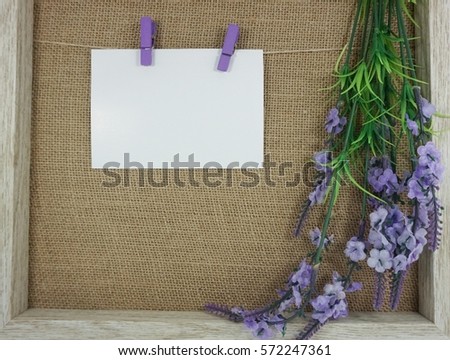 Blank note on cork notice board and replica of flower