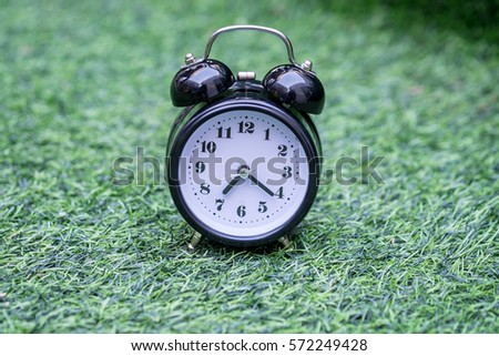 Retro alarm clock on grass