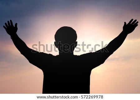 silhouette of a man with hand up on sunset background, The concept of the winner, freedom, liberation, and the blessings of God