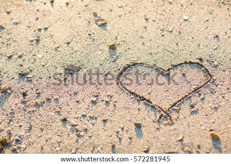 Heart drawn in the sand. Beach background. Top view.drawing a heart on the wet sand at the sea.