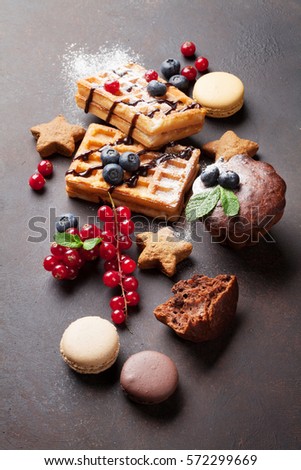 Waffles, candies and sweets on stone table 