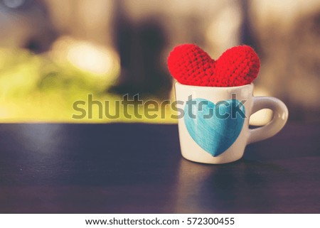 Valentine decorative with red heart knitting shape in white cup on wooden table ,Image for happy valentine day concept.