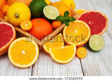 Fresh citrus fruits on a old wooden table Royalty-Free Stock Photo #572320192