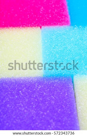Cleaning kitchen sponge texture as background. Colorful yellow pink green purple blue multicolor sponges. Close up macro about sponges. Sponge pattern textures concept background wallpaper material.