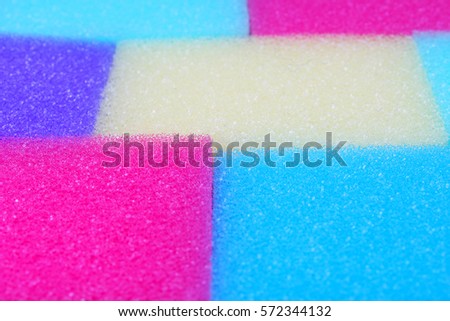 Cleaning kitchen sponge texture as background. Colorful yellow pink green purple blue multicolor sponges. Close up macro about sponges. Sponge pattern textures concept background wallpaper material.