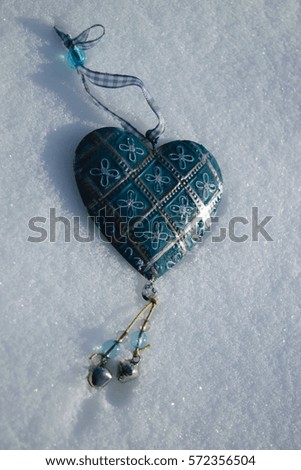 blue vintage heart with floral ornament closeup on the white snow